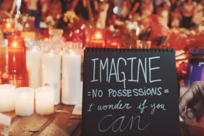 Un dels fotogrames del vídeo, on es pot llegir «Imagina que no hi ha possessions, em pregunto si pots».