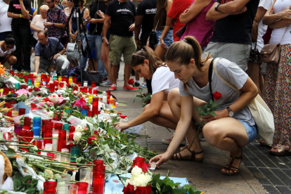 Dos chicas encienden velas en las Ramblas, en uno de los puntos improvisados de recuerdo a las víctimas de los atentados, en una imagen de archivo.
