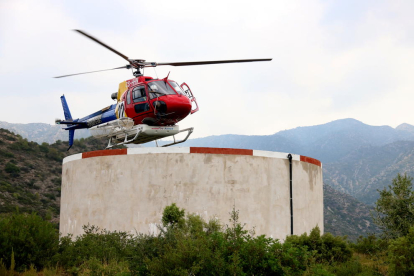 Un helicóptero de los Bombers cargando agua en la extinción del incendio a Tivenys.