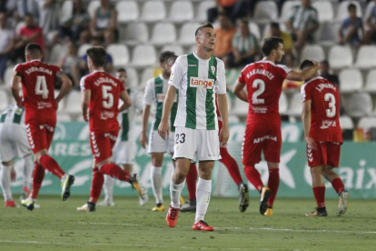 Markovic, del Córdoba, es lamenta per la golejada. Al fons de la imatge, jugadors del Nàstic celebrant un dels gols anotats diumenge.