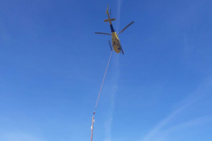 L'helicòpter realitzant els treballs a la línia elèctrica de difícil accés.