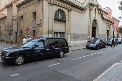 Los coches funerarios en el exterior de la iglesia.