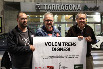 Carlos Montejano, José Tabuyo i Daniel Pi sostenen una pancarta demanant «trens dignes».