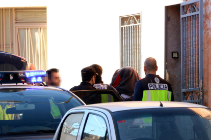 Agents de la policia espanyola s'emporten una de les persones detingudes després de l'escorcoll d'una casa al carrer Cánovas d'Amposta. Imatge del 16 de novembre de 2017