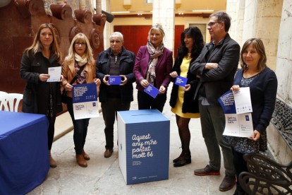 Plano general de la concejala de Comerç de l'Ajuntament de Tarragona, Elvira Ferrando, con representantes de asociaciones comerciales de la ciudad mostrando los materiales de la campaña navideña.