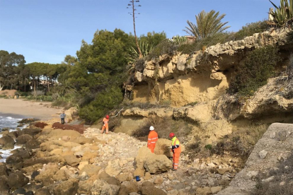Los operarios trabajando, ayer, en la trituración de las rocas, en la playa del Fortín de Altafulla.