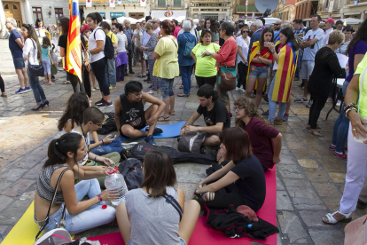 Un grup de joves assegut al terra de la plaça Mercadal