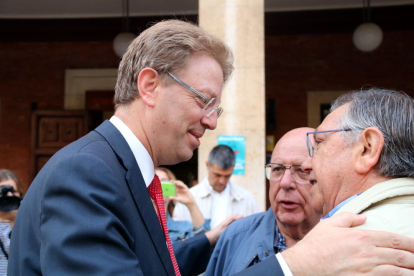 Primer plano del alcalde de Tortosa, Ferran Bel, abrazándose a dos ciudadanos en las puertas del Ayuntamiento antes de marcharse a Madrid para comparecer ante el Fiscal.