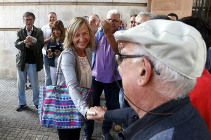 Pla mig de l'alcaldessa de Cunit, Montse Carreras, rebent el suport d'un veí davant l'Audiència de Tarragona.