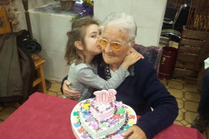Amèlia Guardià de 106 años recibiendo un detalle de su bisnieta Amèlia Ventura de 5 años.