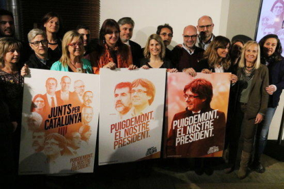 Los miembros de la candidatura de Junts per Catalunya aguantando el tres carteles con el lema de la campaña.