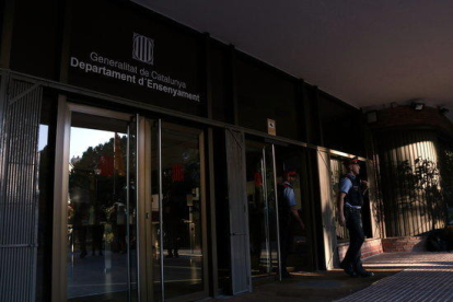Pla sencer de dos agents dels mossos d'esquadra sortint del Departament d'Ensenyament a quarts de 9 del matí del 30 d'octubre de 2017.