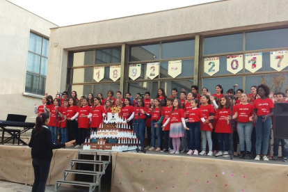 Imagen de los alumnos cantando una canción conmemorativa con el pastel hecho por el AMPA de la escuela.