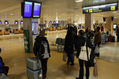 Passatgers fent cua per facturar la seva maleta al mostrador de Ryanair, abans d'agafar un dels vols que la companyia de baix cost irlandesa opera des de l'aeroport de Girona