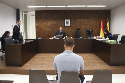 Plano medio de Andreu Curto, de espalda, sentado durante el juicio en la Ciudad de la Justicia.