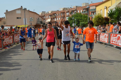 La pequeña Txell García, con camiseta azul, corriendo con su padre y su primo.