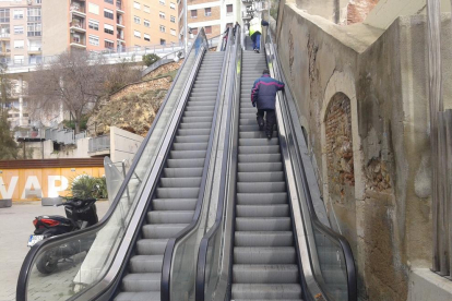 Dues persones pugen pel tram avariat, com si es tractés d'unes escales convencionals.