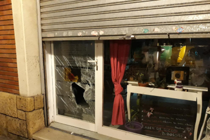 Imatge del vidre de la botiga trencat després de ser colpejat pel lladre.