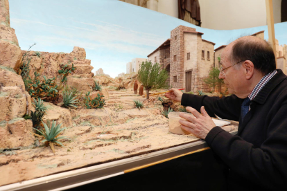 Josep Puig retoca con un pincel un camino que pertenece a uno de los espacios del diorama.
