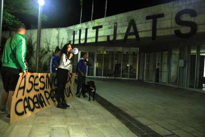 Quatre persones escridassen el detingut pel crim de la nena de Vilanova i la Geltrú des de fora els jutjats, amb una pancarta.