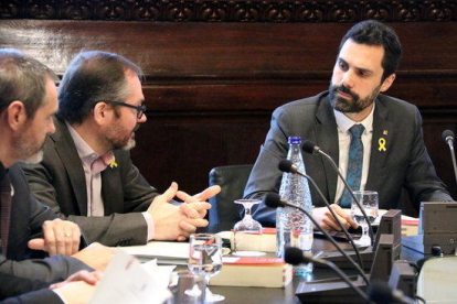 El presidente del Parlament, Roger Torrent, mira a los diputados de JxCat Eusebi Campdepadrós y Josep Costa en la reunión de la Mesa, el 20 de febrero de 2018.