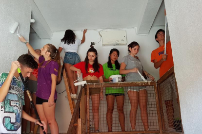Los jóvenes pintando el último rellano del bloque de pisos de Campclar que han estado arreglando.
