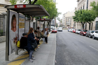 Plano general de varios usuarios esperando el autobús en la parada de Pau Casals, durante el paro parcial convocado por los conductores del EMT de Tarragona.