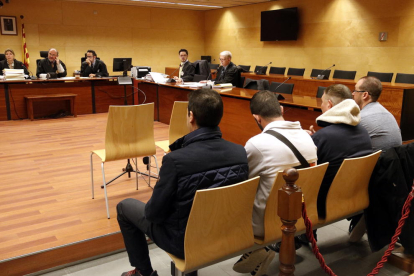 Los cuatro acusados, entre los cuales hay dos guardias civiles, sentados en el banquillo de la Sección Tercera de la Audiencia de Girona.