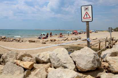 Imatge de la platja de Segur de Calafell amb una cinta policial que delimita el perímetre per un vessament fecal.