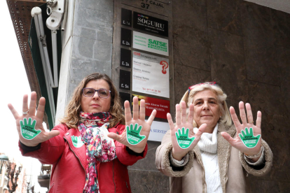Kati Ródenas, a la dreta, i una companya del sindicat, mostres pegatines de la campanya.