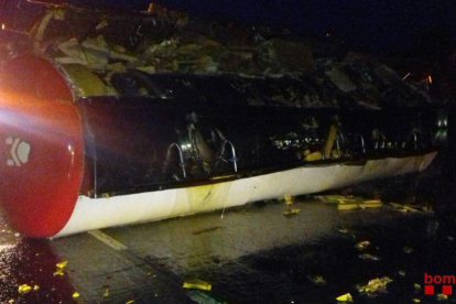Imatge cedida pels Bombers d'una cisterna de camió bolcada després d'un accident a la N-340, a Alcanar (Montsià), el 9 de maig del 2018. Pla general