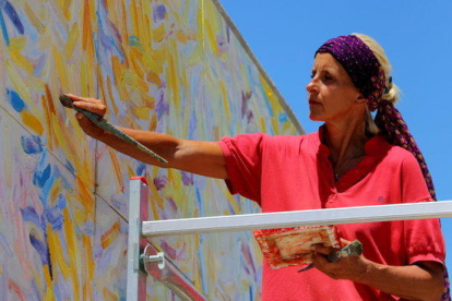 La pintora Ursula Jüngst haciendo los últimos retoques a su cuadro 'La fiesta de la vida'.