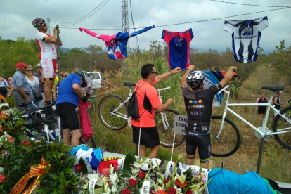 Els ciclistes penjant mallots en record de les dues víctimes just on van perdre la vida