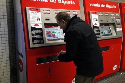 Imatge d'arxiu d'un usuari davant una màquina expenedora al Metro de BArcelona.