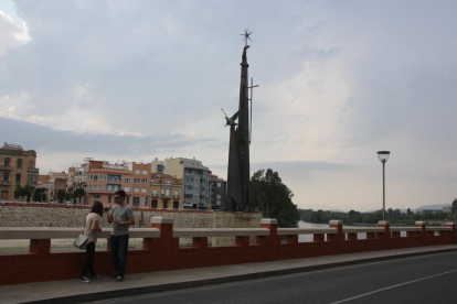 Una pareja se fotografía delante del monumento franquista de Tortosa.