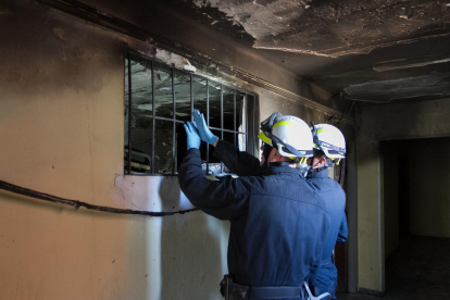 L'interior del pis de l'habitatge incendiat a Reus, amb tècnics revisant-lo.