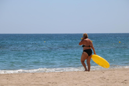 Pla general d'una dona amb un flotador a la platja de Torredembarra aquest 15 de juny del 2018 (Horitzontal).