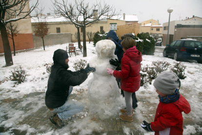 Infants fent un ninot de neu a l'Espluga de Francolí.