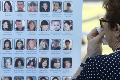Una dona plora davant les imatges de les víctimes de l'accident de l'avió d'Spanair durant un acte d'homenatge.