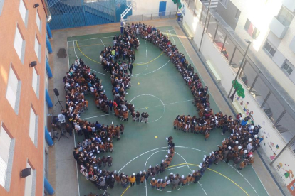 Alumnes i professors van formar un colom de la pau al pati de l'escola.