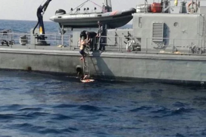 La mujer sube en el barco tras ser rescatada
