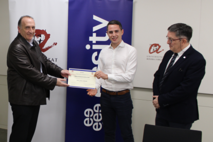 Toni Mata, director de Operaciones de Essity en España entrega el galardón al estudiante Enric Prats, delante del rector Josep Anton Ferré.