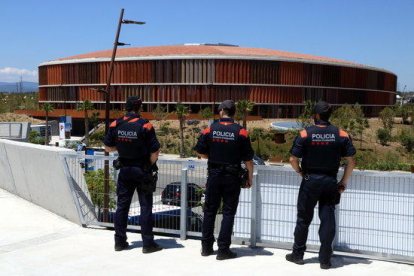 Pla general de tres agents de la unitat ARRO dels Mossos d'Esquadra, d'esquenes, en un punt estàtic de vigilància a l'Anella Mediterrània de Tarragona, amb el Palau d'Esports Catalunya al fons.