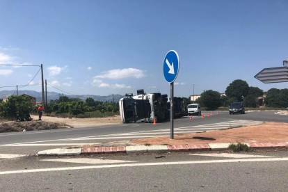 Una camió ple de pinso ha bolcat a la rotonda dels nusos de Tortosa.