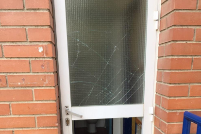 Imagen de una de las puertas con los cristales rotos a la Escola Cèsar August.