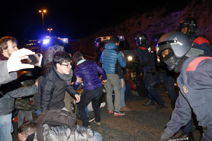 Plan|Plano medio de efectivos ARRO de los Mossos D'Esquadra cargando con las porras para disolver la concentración que cortaba la autovía A-7, en Tarragona, en sentido sur. Imagen del 23 de marzo del 2018