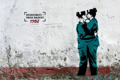 La imatge recorda un dels grafitis més icònics de Banksy a Londres on hi ha dos policies besant-se.