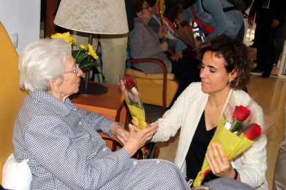 Dolors Montserrat entrega una rosa a una dona.
