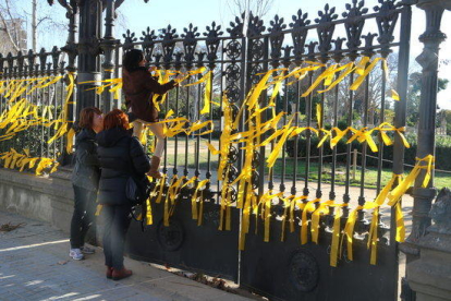 Imagen de gente atando lazos amarillos a la reja del parque de la Ciutadella, donde se produjo la agresión.