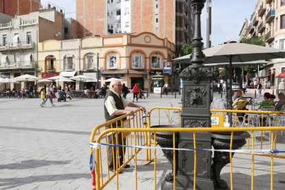 Una persona observa al detall la font que s'ha instal·lat a la plaça Corsini.